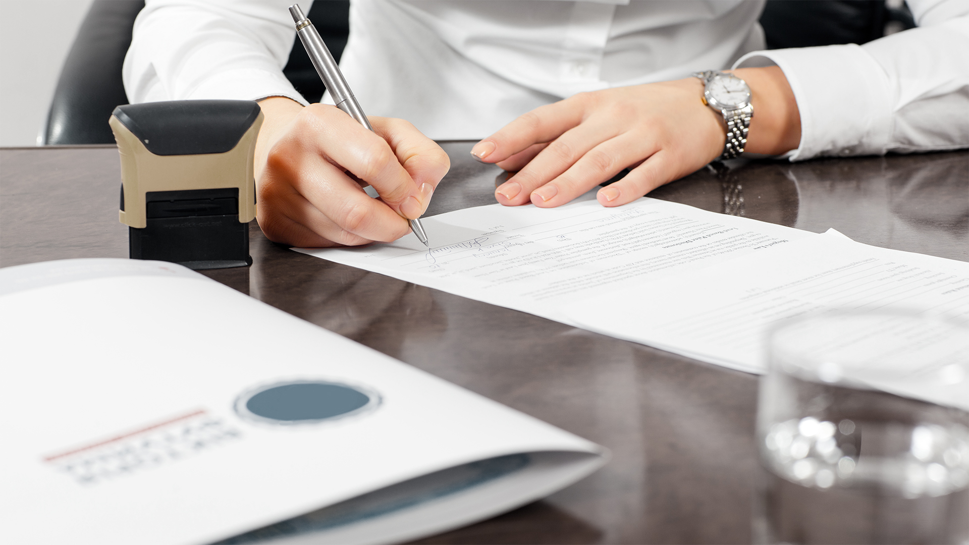 Person signing paper with stamp